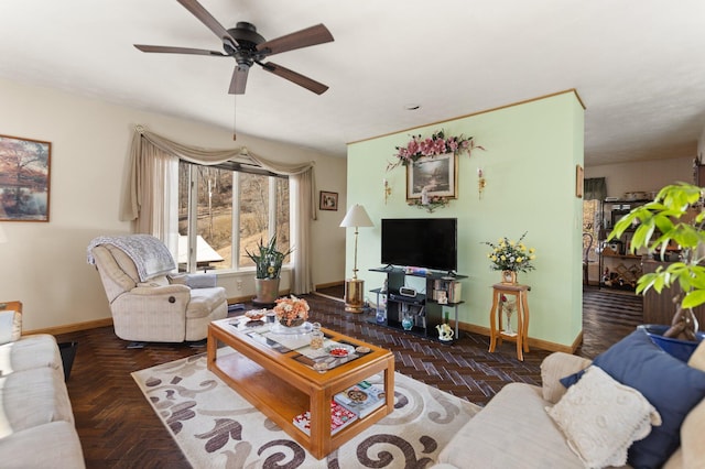 living area with a ceiling fan and baseboards