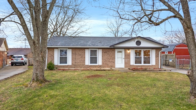 ranch-style house with a gate, brick siding, fence, and a front lawn