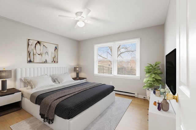 bedroom featuring a ceiling fan, a baseboard radiator, and light wood finished floors