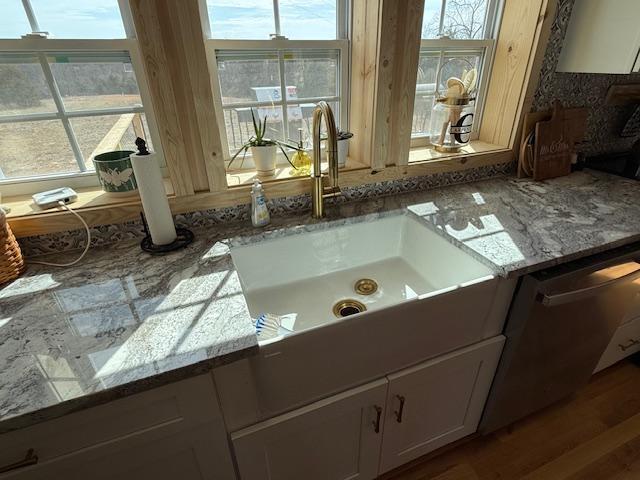 interior details featuring light stone countertops and wood finished floors