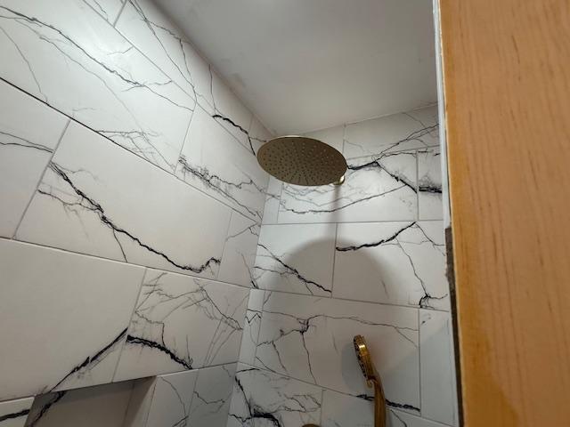 interior details featuring tiled shower