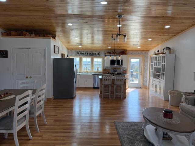 living area featuring recessed lighting, light wood-style floors, and wooden ceiling