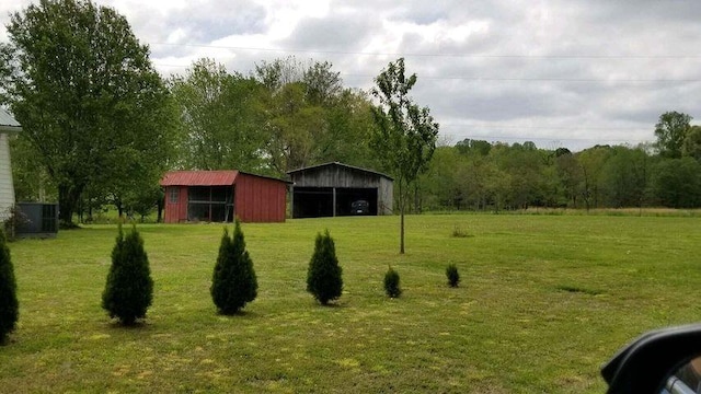 view of community featuring a carport, an outbuilding, and a yard