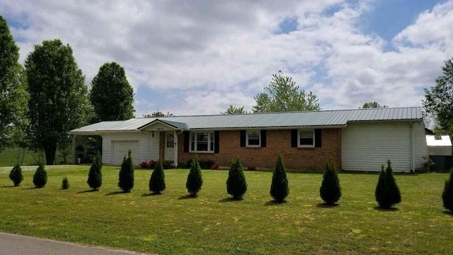 ranch-style house with metal roof, an attached garage, brick siding, driveway, and a front lawn