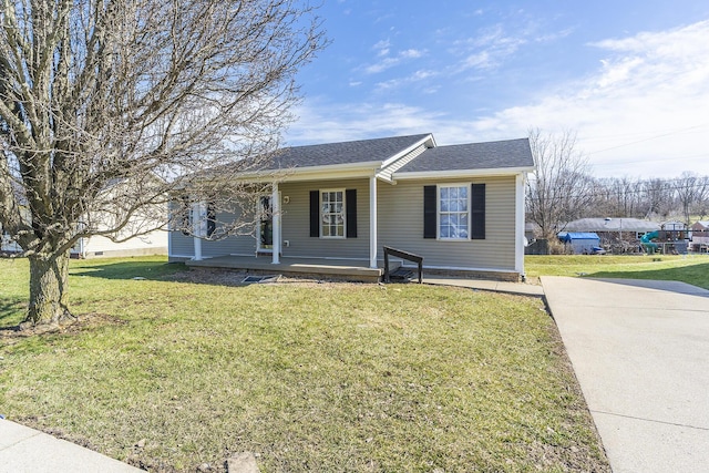 bungalow with covered porch, roof with shingles, and a front yard