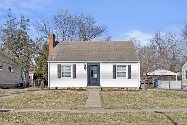 view of front facade featuring a front yard, central AC, fence, and a chimney