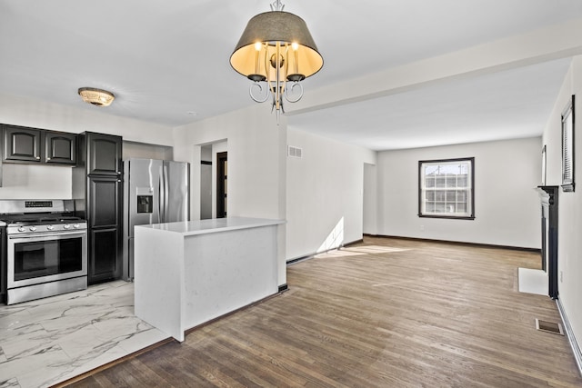 kitchen featuring appliances with stainless steel finishes, a chandelier, visible vents, and light wood-style floors