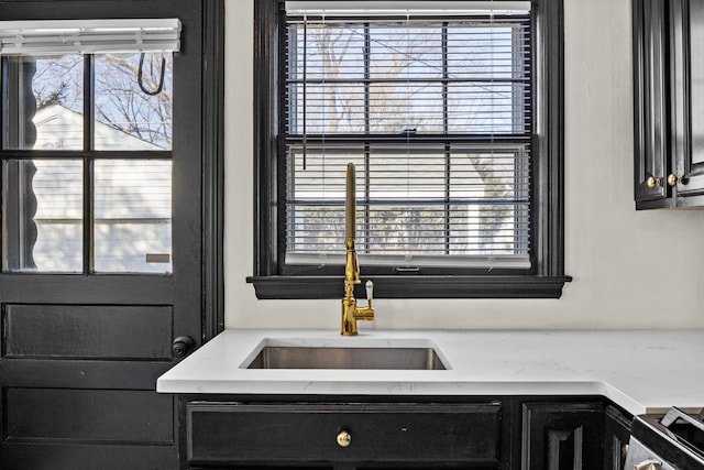 details with light countertops, a sink, stainless steel range with electric stovetop, and dark cabinets