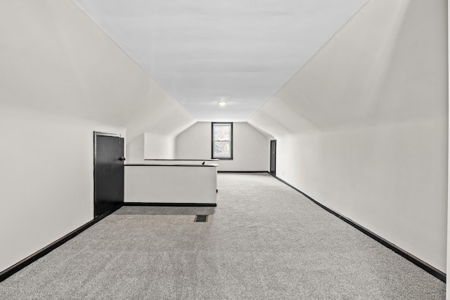 additional living space featuring vaulted ceiling, carpet, and baseboards