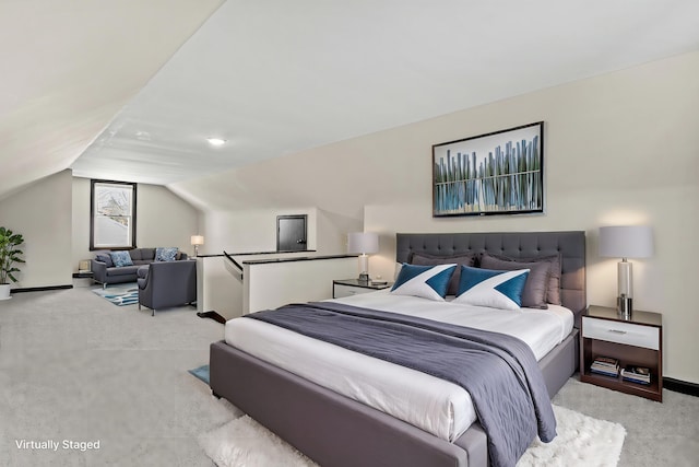 carpeted bedroom with vaulted ceiling and baseboards