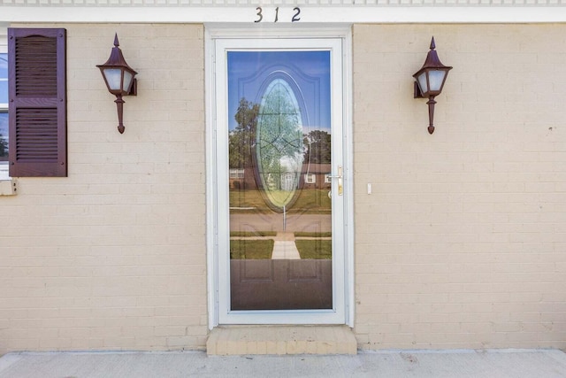 doorway to property featuring brick siding