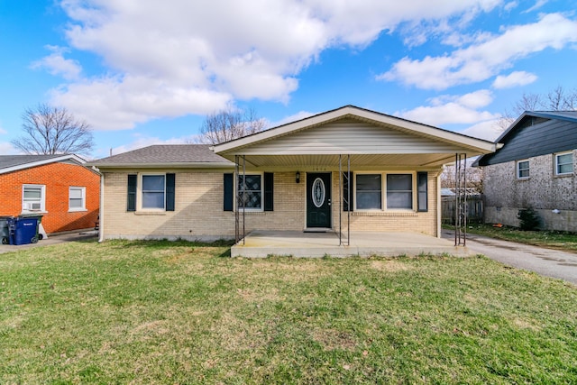 ranch-style home with covered porch, a shingled roof, a front lawn, and brick siding