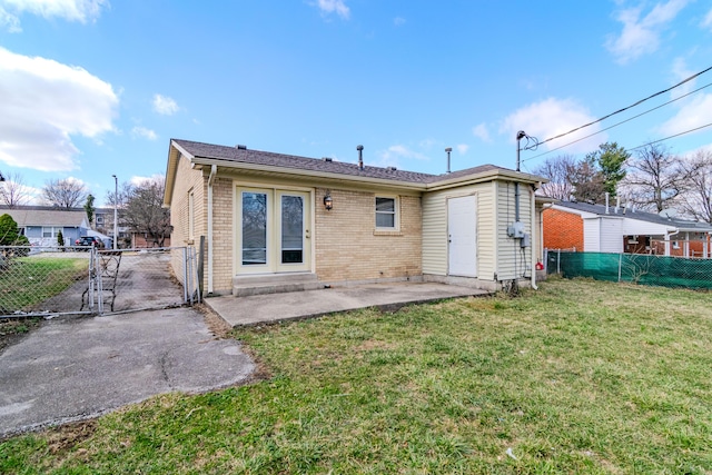 back of property with a lawn, a fenced backyard, a gate, a patio area, and brick siding