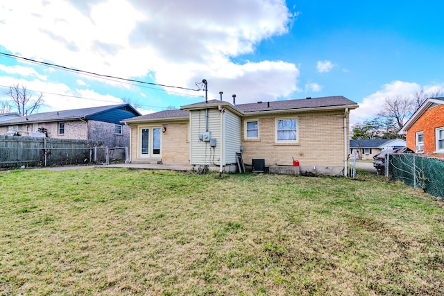 back of property with a lawn, a patio, a fenced backyard, central AC, and brick siding