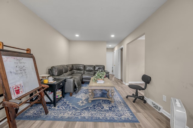 living area with recessed lighting, visible vents, baseboards, and wood finished floors