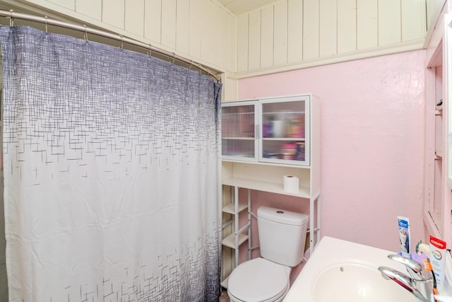 full bath with a shower with shower curtain, a sink, and toilet