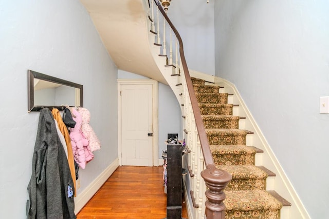 staircase with wood finished floors and baseboards