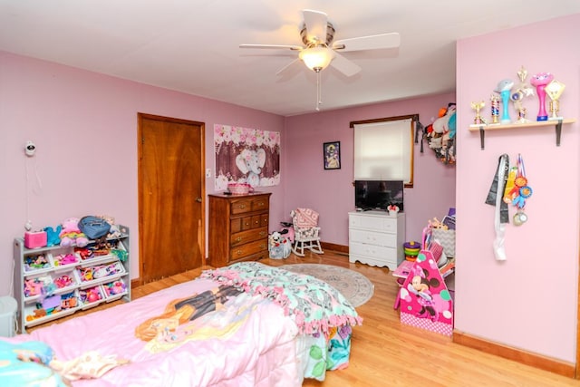 bedroom featuring ceiling fan, baseboards, and wood finished floors