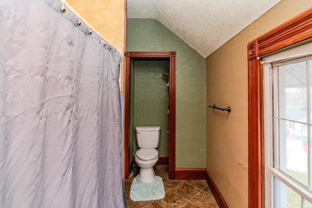 full bath with lofted ceiling, toilet, baseboards, and tile patterned floors