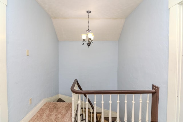 stairway with vaulted ceiling, carpet, baseboards, and a notable chandelier