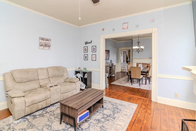 living area with hardwood / wood-style flooring, baseboards, and crown molding