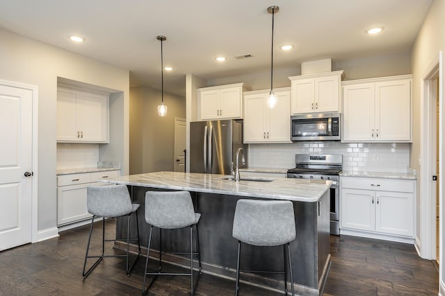 kitchen with stainless steel appliances, a sink, visible vents, white cabinets, and dark wood-style floors