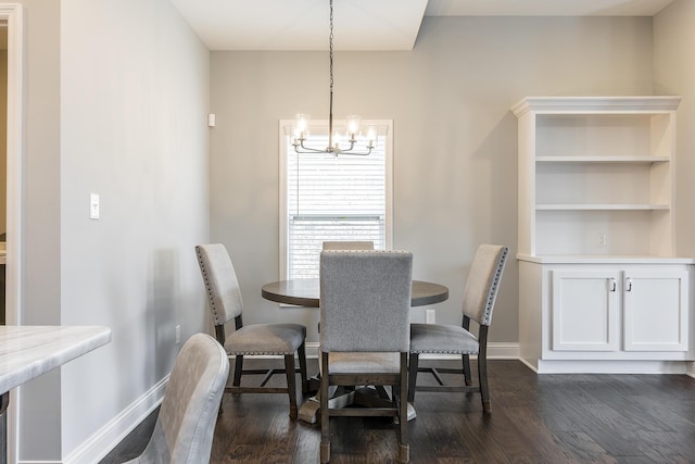 dining space featuring dark wood-style floors, baseboards, and an inviting chandelier