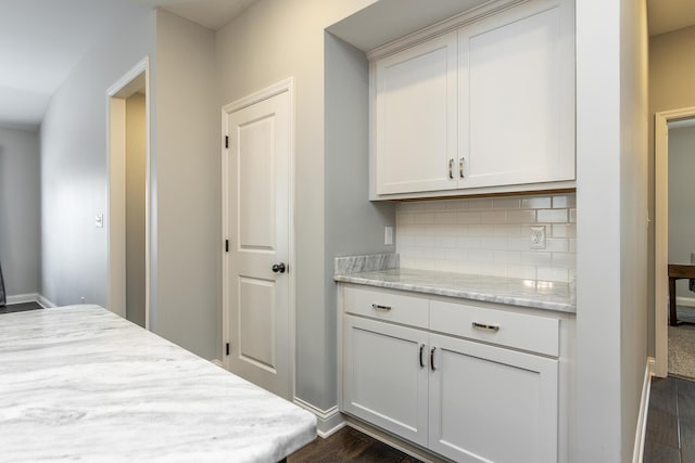 interior space featuring baseboards and dark wood finished floors