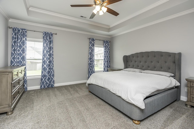 bedroom featuring carpet flooring, visible vents, baseboards, ornamental molding, and a tray ceiling