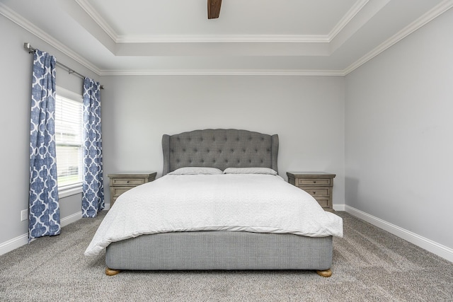 carpeted bedroom with crown molding, a raised ceiling, a ceiling fan, and baseboards