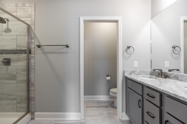 bathroom with baseboards, a shower stall, toilet, and vanity