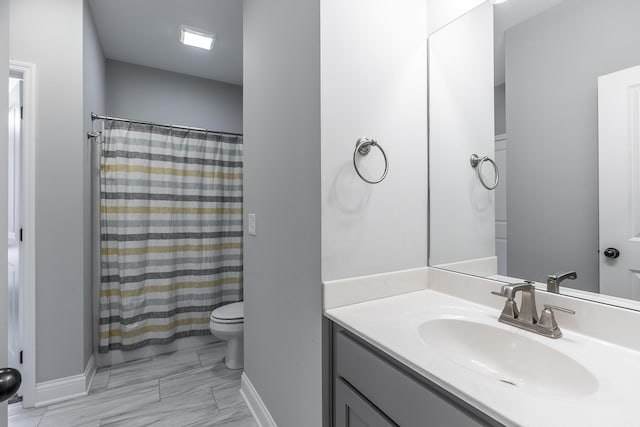 bathroom featuring toilet, baseboards, a shower with shower curtain, and vanity