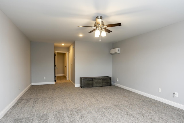 unfurnished room with a ceiling fan, carpet flooring, a wall mounted air conditioner, and baseboards