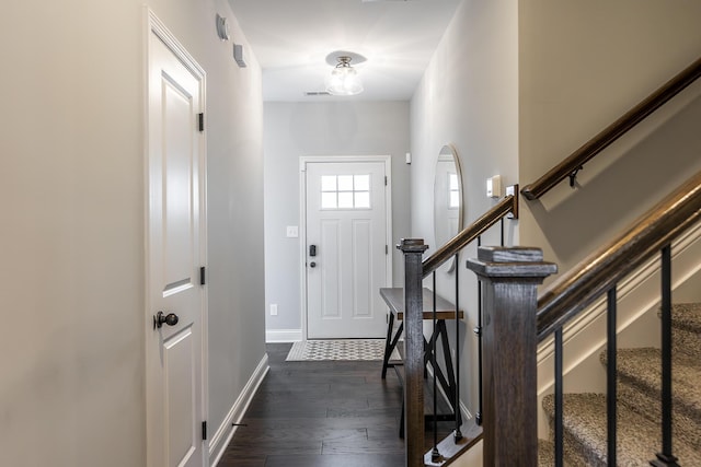 entryway featuring dark wood-type flooring, stairway, visible vents, and baseboards