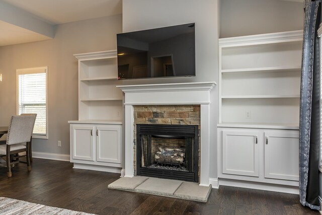 living area featuring a fireplace, baseboards, and dark wood finished floors