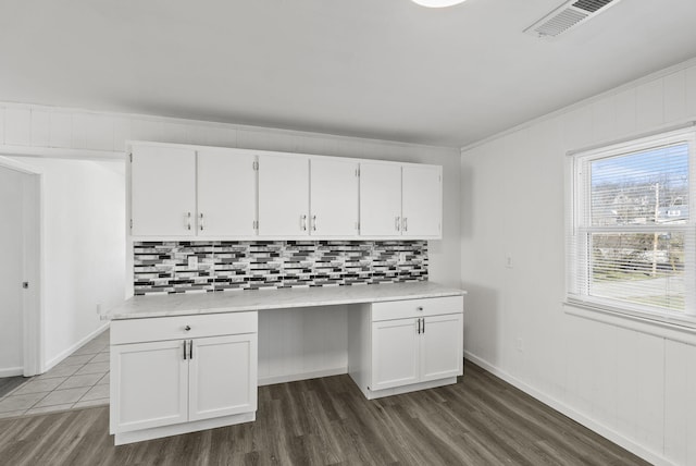 kitchen featuring white cabinetry, visible vents, light countertops, and built in study area