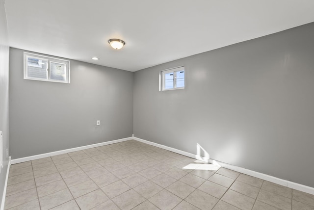 basement featuring light tile patterned flooring and baseboards