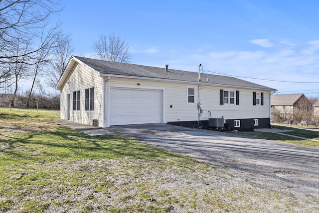 exterior space featuring a garage, cooling unit, and a front lawn