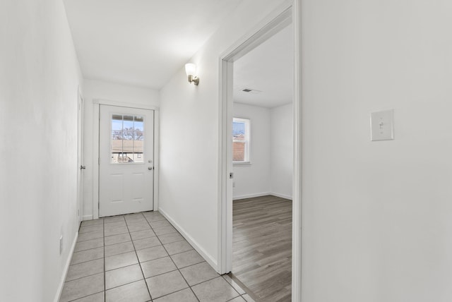 doorway to outside with visible vents, plenty of natural light, baseboards, and light tile patterned floors