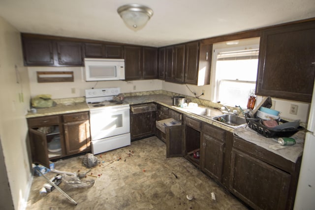 kitchen with dark brown cabinetry, white appliances, and a sink