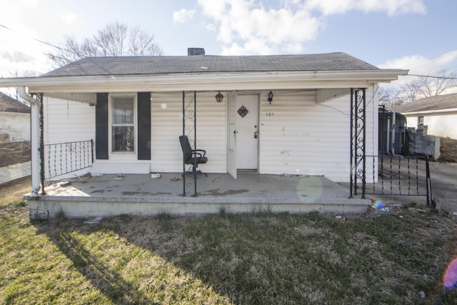 bungalow-style home with covered porch and a shingled roof