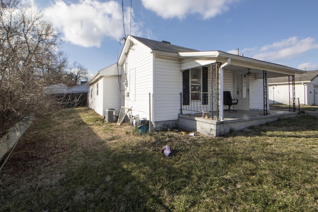 view of side of property featuring central AC and a lawn