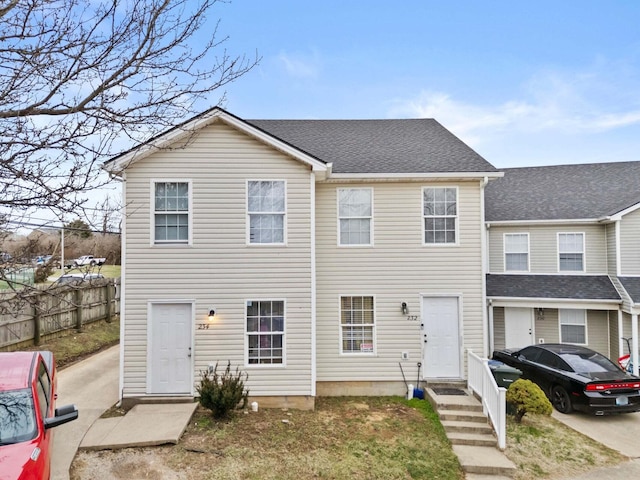 view of front of house featuring a shingled roof and fence