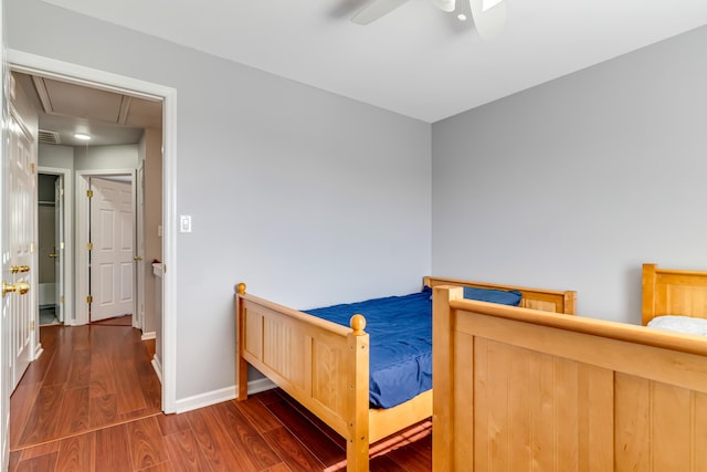 bedroom with visible vents, attic access, ceiling fan, wood finished floors, and baseboards