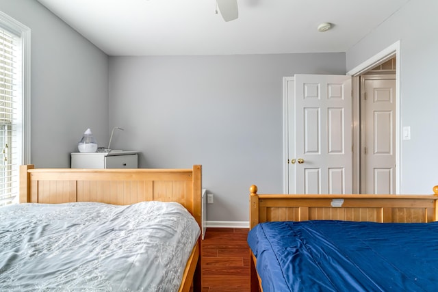 bedroom with ceiling fan, baseboards, and dark wood finished floors