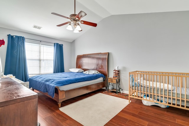 bedroom with ceiling fan, wood finished floors, visible vents, baseboards, and vaulted ceiling