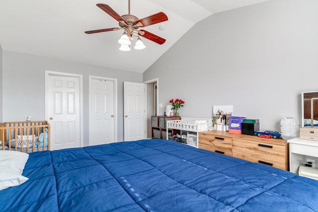 bedroom featuring high vaulted ceiling, two closets, and a ceiling fan