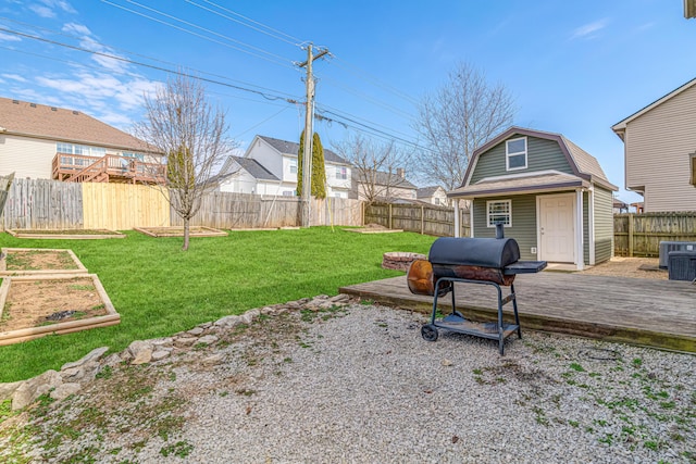 view of yard featuring central AC unit, a vegetable garden, a fenced backyard, an outbuilding, and a deck