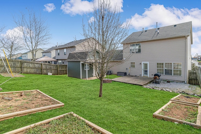 back of house featuring a garden, a yard, a fenced backyard, and a wooden deck