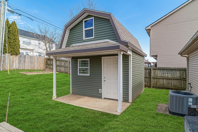 view of outdoor structure featuring an outbuilding, a fenced backyard, and central air condition unit